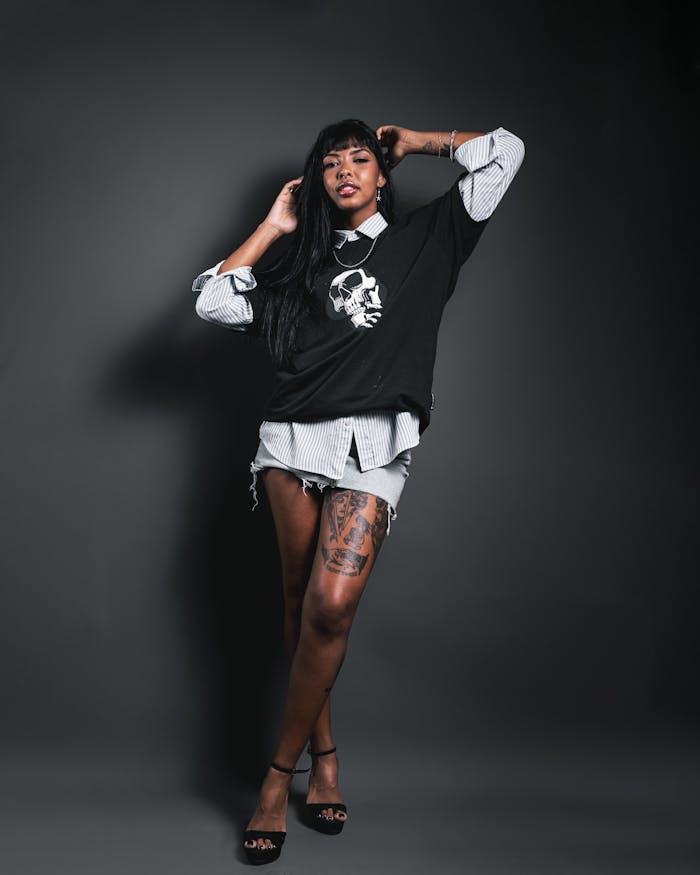Fashionable woman poses in chic outfit with skull print, showcasing edgy style.