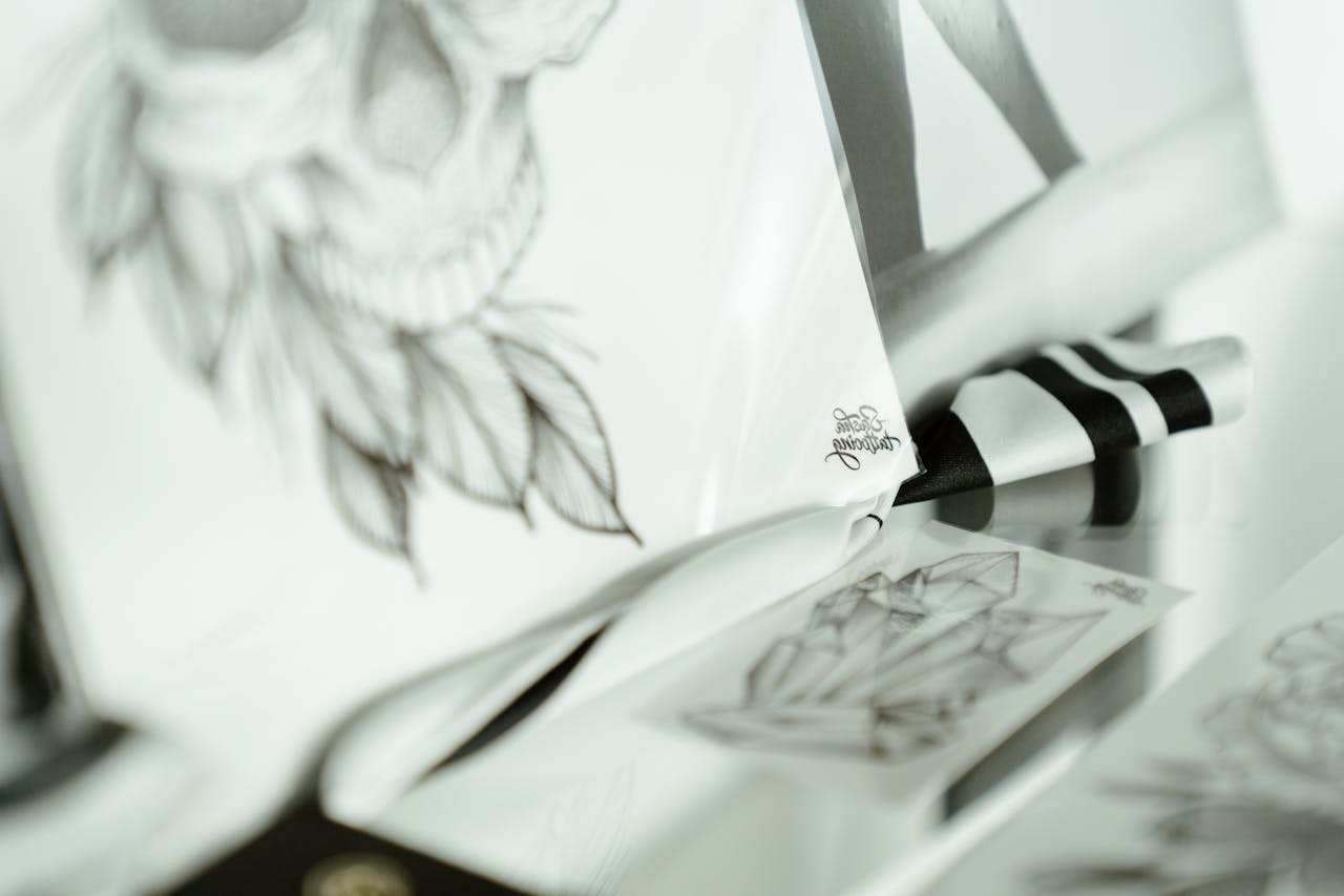 Close-up view of artistic tattoo sketches on a desk, showcasing creative design process.